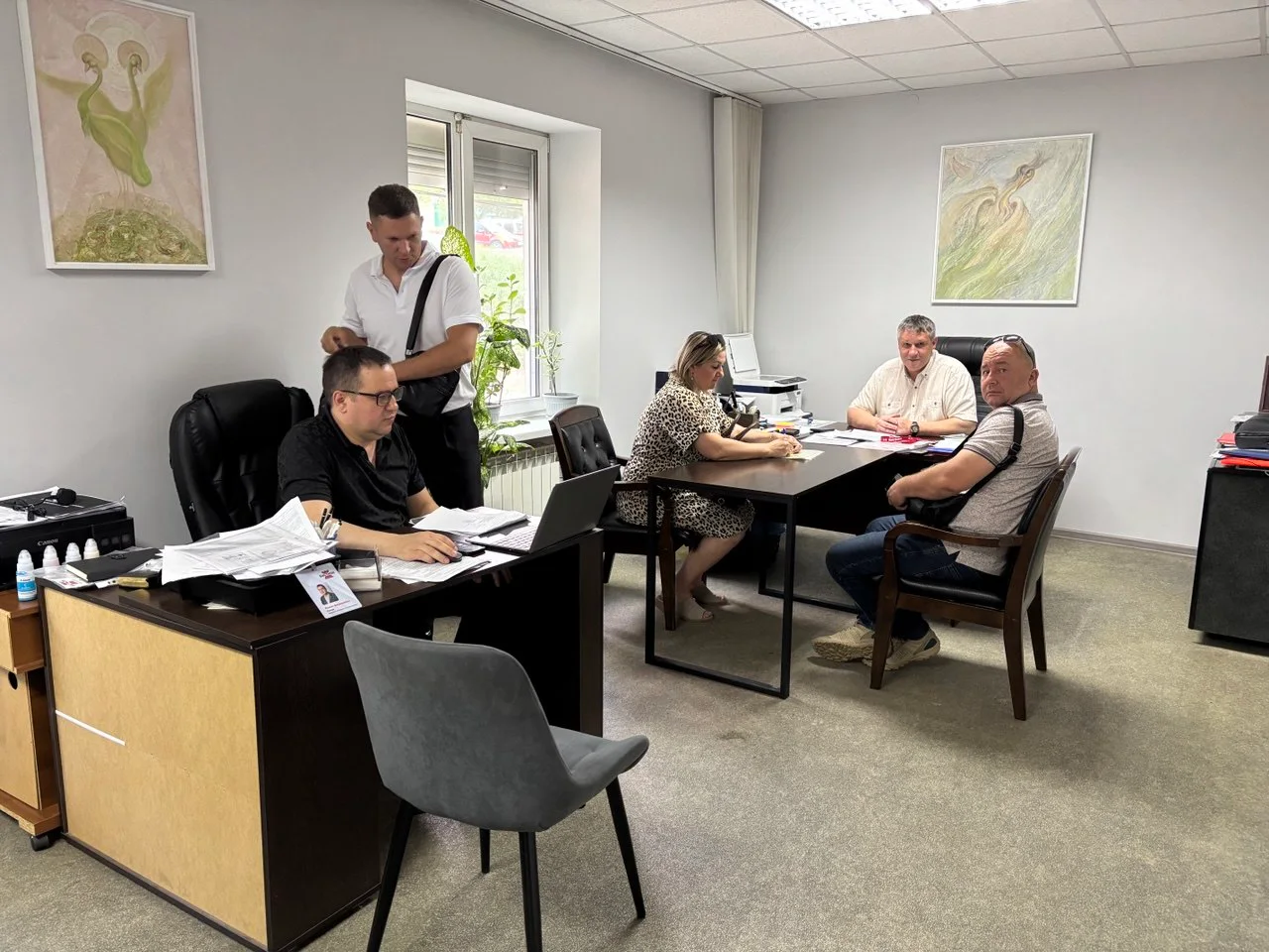 Сотрудники и клиенты агентства Бастион обсуждают сделку в офисе